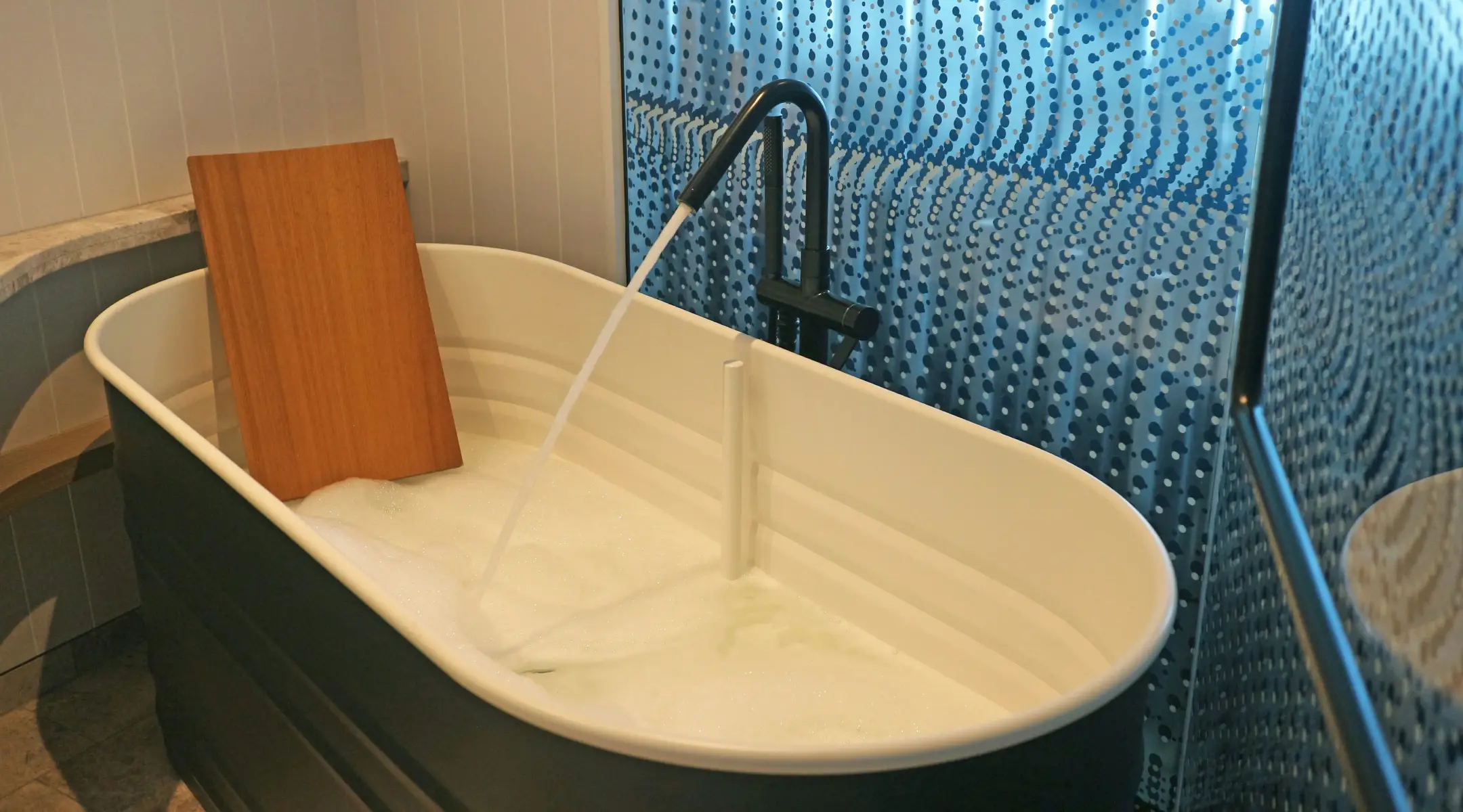 a white bath tub sitting next to a walk in shower